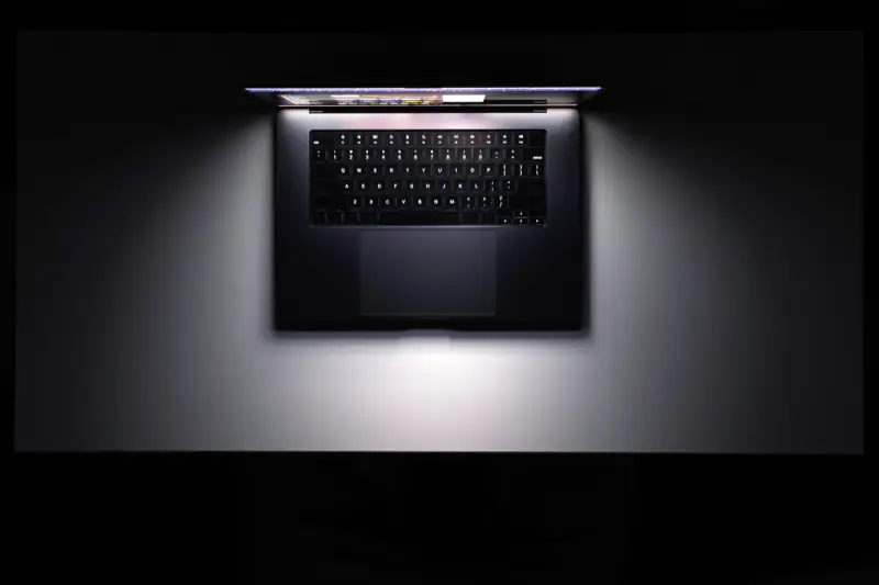 Laptop z podświetloną klawiaturą w ciemnym pomieszczeniu